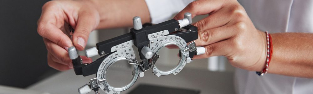 Female hands holding the optical device for eye testing Best Contact Lenses in Habsiguda